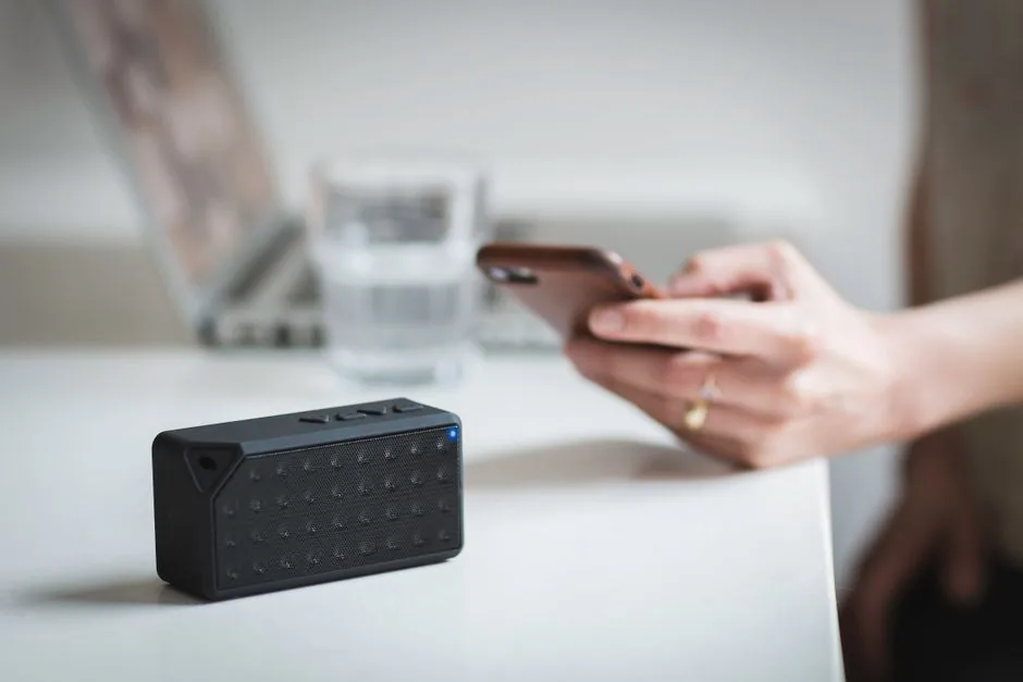 Hand verbindet ein Smartphone mit einem kabellosen Lautsprecher