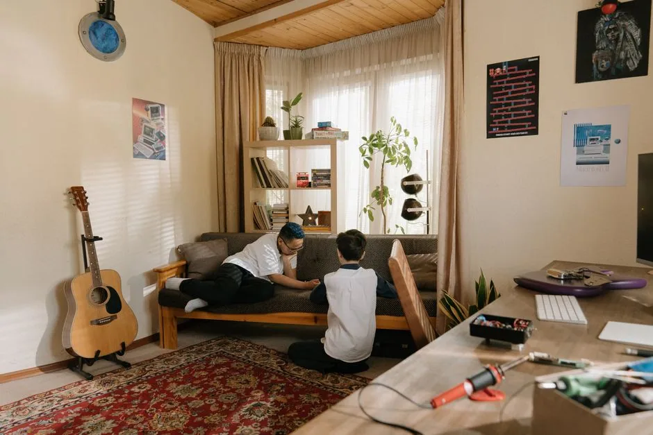 Zwei Jugendliche spielen in einem Zimmer mit Gitarre und Deko