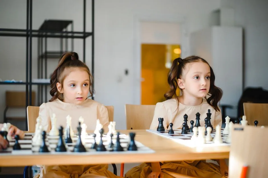 Zwei Schwestern spielen konzentriert Schach
