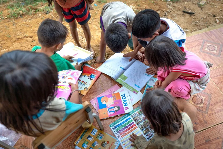 Kinder lesen im Freien gemeinsam in Büchern