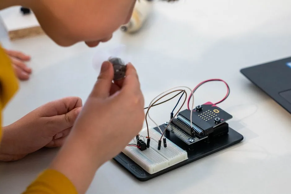 Kind baut an einer Werkbank eine elektronische Schaltung zusammen