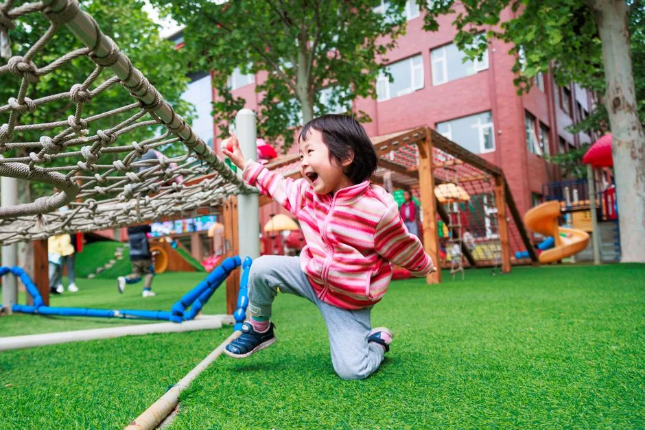 Kind spielt vergnügt auf einem hellen Spielplatz
