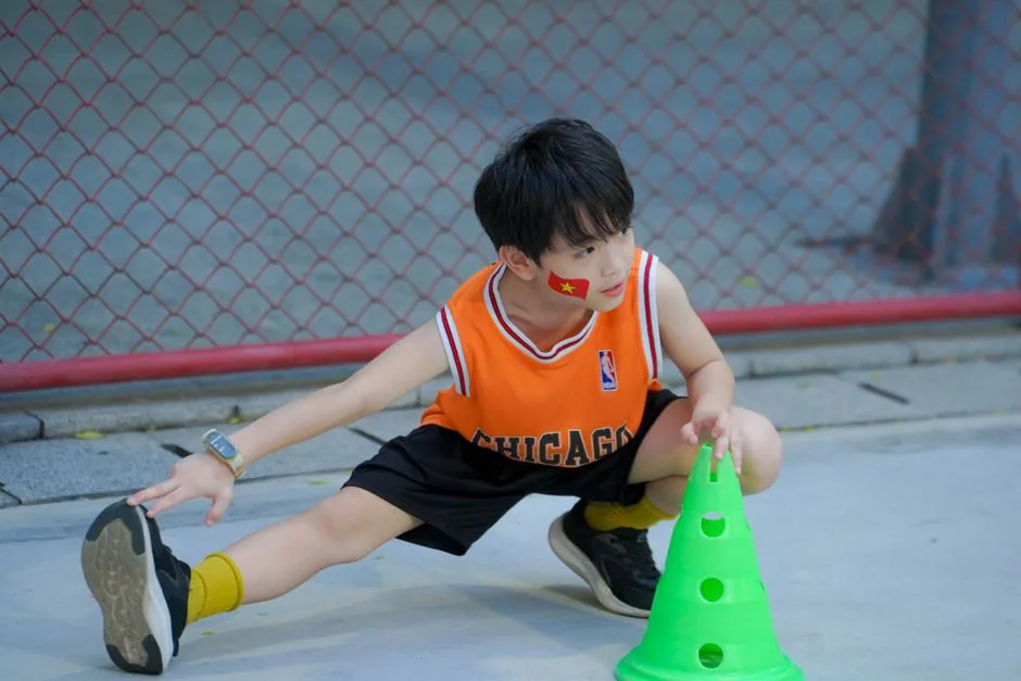 Junge im Basketballtrikot dehnt sich vor dem Training