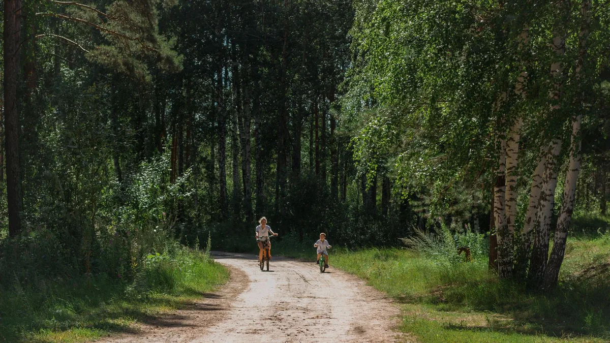 Familie unterwegs mit Fahrrad und Kinderanhänger
