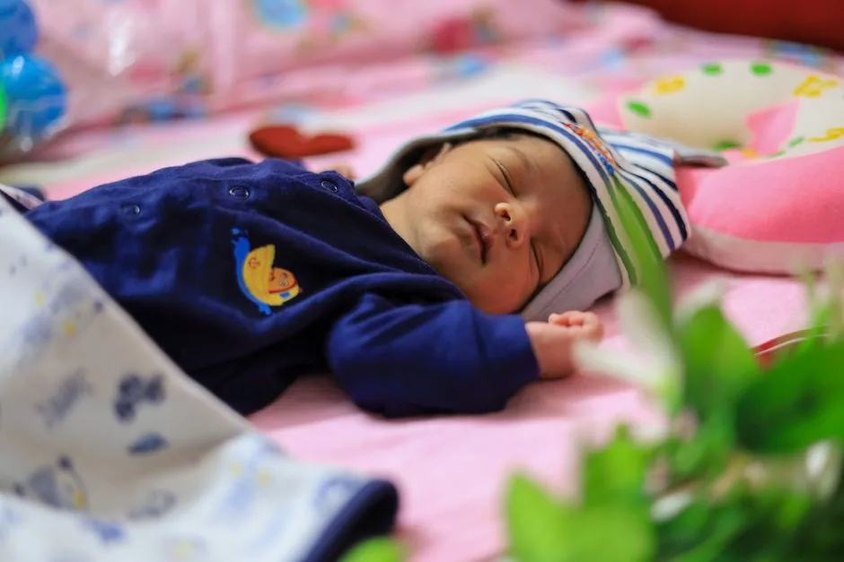Neugeborenes schläft friedlich und sicher im Babybett