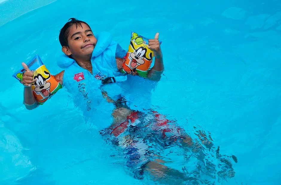 Kind mit Schwimmhilfe im Wasser
