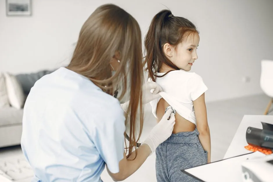 Kinderärztin untersucht aufmerksam ein Kind mit dem Stethoskop