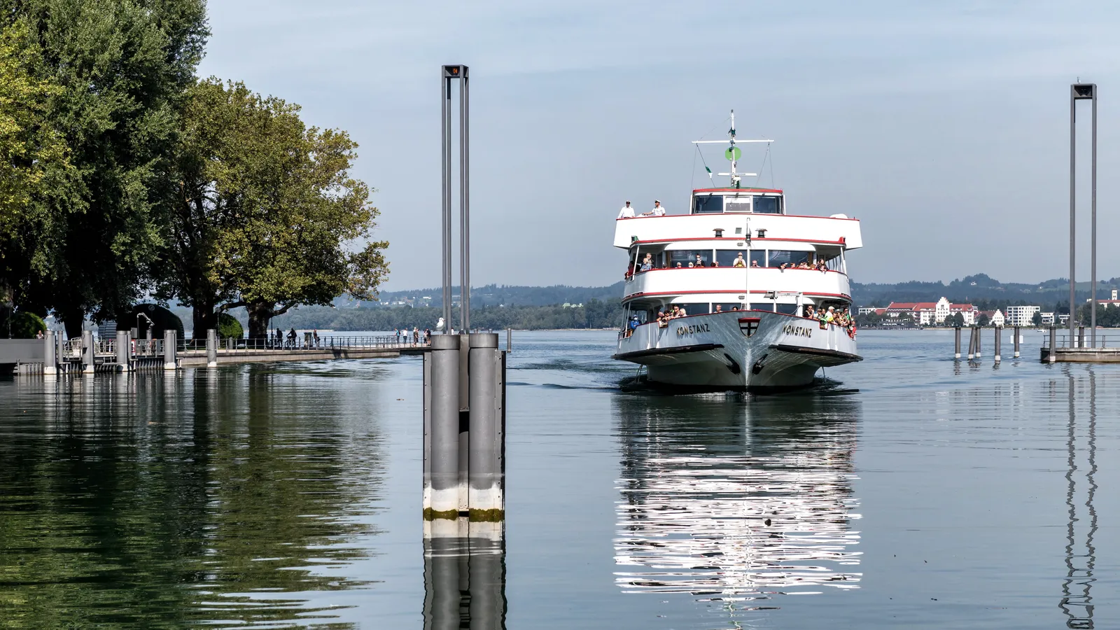 Ausflugsschiff fährt bei ruhigem Wasser in den Bregenzer Hafen am Bodensee ein